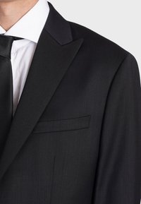 Giacca da smoking nera con rever a picco in satin, taschino sul petto singolo e tessuto testurizzato. Presenta un delicato motivo a righe sottili.