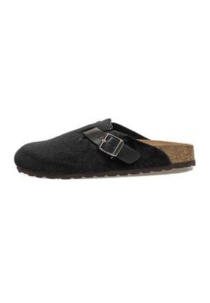 Zueco negro sin suela con plantilla de corcho, parte superior de textura suave y correa negra ajustable con hebilla plateada sobre un fondo blanco.