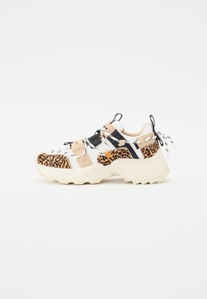 Kraftig sneaker med leopardmønstrede detaljer, beige og sorte stropper, hvidt netmateriale og tyk beige sål, set fra siden mod en hvid baggrund.