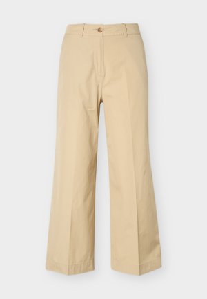 Pantaloni bej cu croială largă, prevăzuți cu nasture și fermoar, bucle pentru curea și un design frontal simplu, afișați pe un fundal alb.