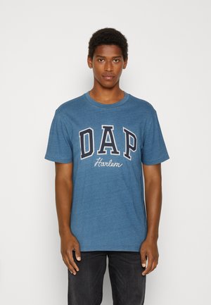 Blue cotton t-shirt with short sleeves, featuring "DAP" in bold white letters and "Harlem" in script, relaxed fit, crew neckline.