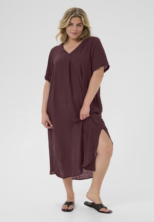 Burgundy knee-length dress with a V-neck, short sleeves, side slits, and lightweight fabric. Worn with black slide sandals.