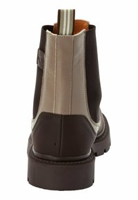 Stivali Chelsea marroni e beige con suola in gomma, materiale in pelle e tela, lati elasticizzati e un tallone con un'etichetta a strisce.