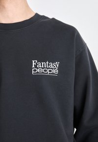 Dunkelgrauer Sweatshirt aus Baumwolle mit weiß gesticktem Text "Fantasy people" auf der Brust. Klassisches Crewneck-Design.