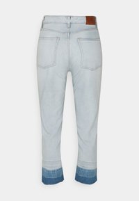 Ljusblå denim capri byxor med fransad nederkant, med en mörkare blå deniminfällning, fem fickor och en brun läderlapp vid bakre midjan.