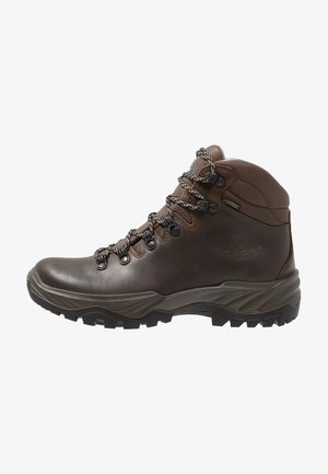 Scarponcino da trekking in pelle marrone con suola spessa e robusta, occhielli metallici, lacci con motivo, supporto per la caviglia e etichetta Gore-Tex sul lato.