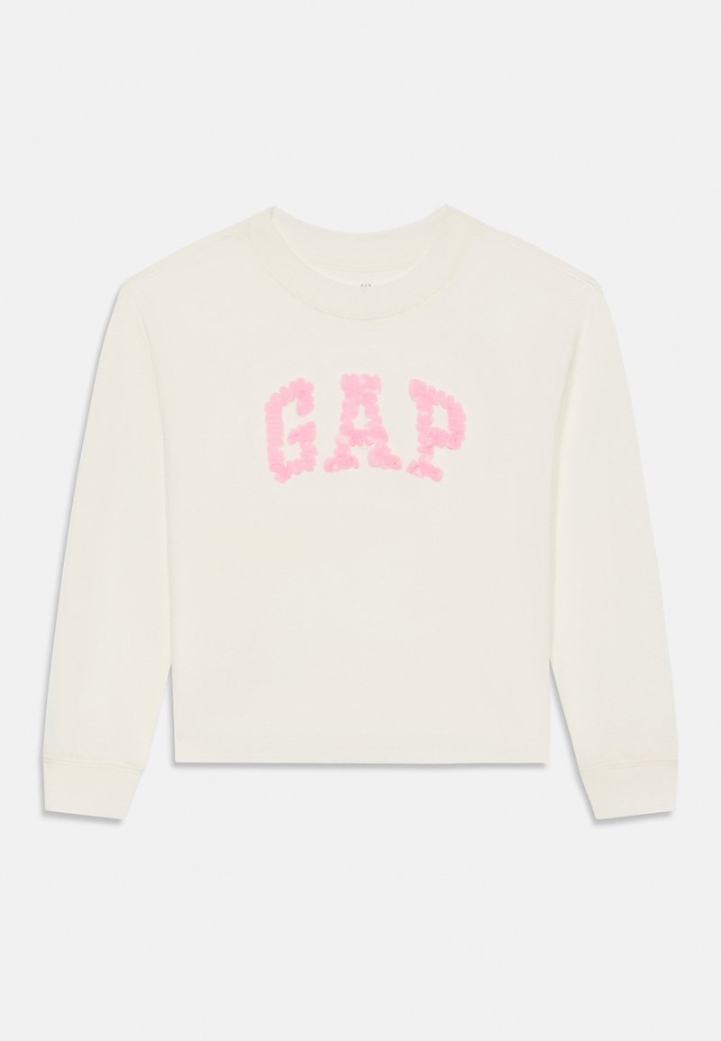 Fehér, hosszú ujjú, kerek nyakú pulóver, pink virágmintázatú "GAP" logóval a mellkasán, bordázott mandzsettákkal és laza fazonnal.