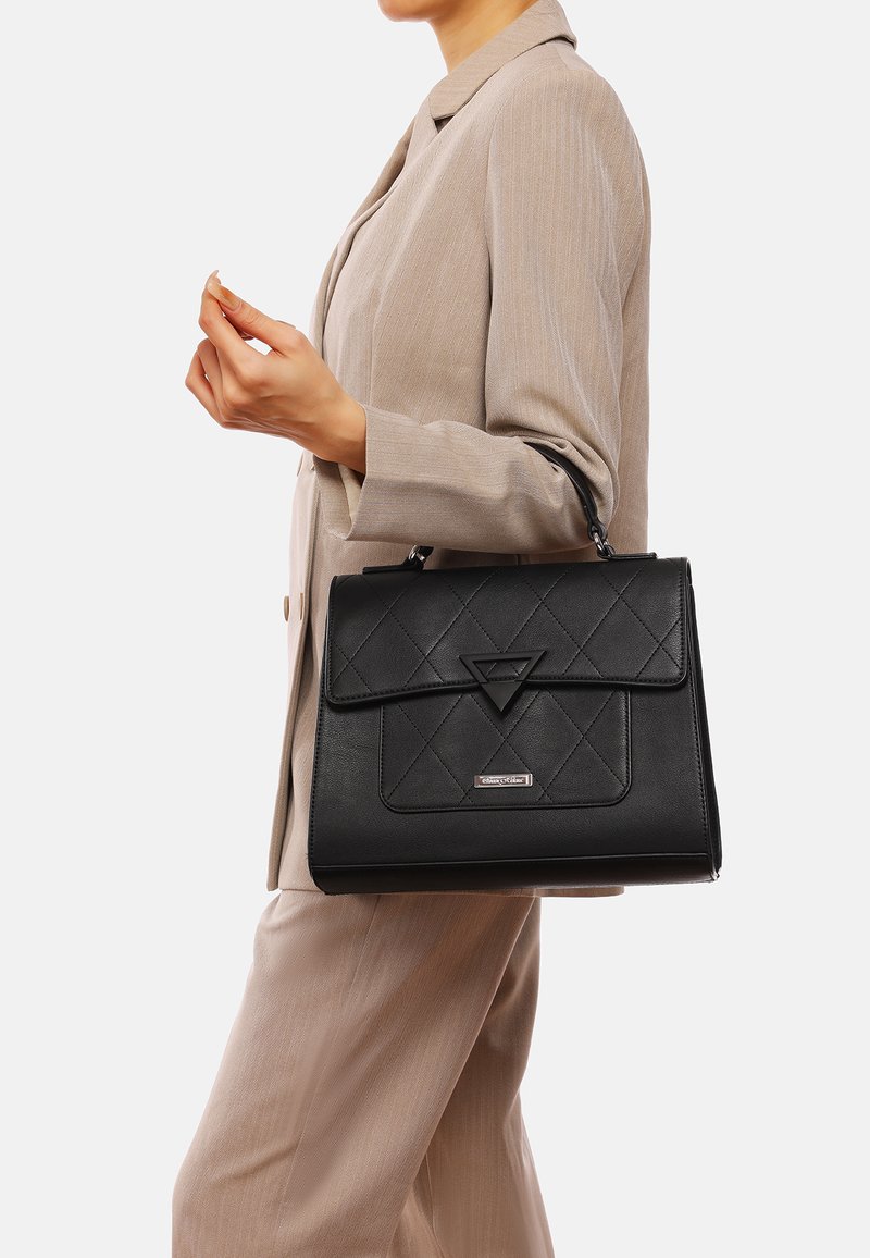 Borsa a mano in pelle nera con design trapuntato, accento triangolare e forma strutturata con manico superiore e chiusura magnetica.