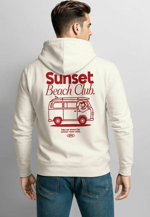 Cream-colored hoodie featuring a graphic of a van and text reading "Sunset Beach Club." Note the relaxed fit and soft texture.