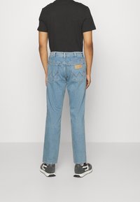 Ljusblå denimjeans med rak passform, bakfickor med ett zigzagmönster och en märkesläderpatch på midjebandet.