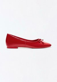 Ballerine plate en cuir rouge avec un bout rond et un petit nœud, vue de côté sur fond blanc.
