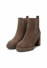 Stivaletti alla caviglia in suede marrone con un pannello in tessuto testurizzato, punta arrotondata e tacco in legno. Presentano linguette per indossarli facilmente.