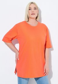 Short-sleeve, round-neck tunic in bright orange cotton, featuring side slits for ease of movement and a relaxed fit.