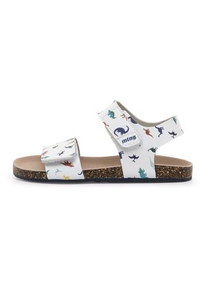 Sandalia blanca para niños con estampados de dinosaurios coloridos, dos tiras ajustables de velcro, suela acolchada de corcho y logo de la marca en la correa lateral.