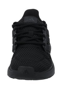 Svart atletisk sneaker med övre del i mesh, snörningssystem och strukturerad sula. Har tre svarta sidostreck och en rundad tå.