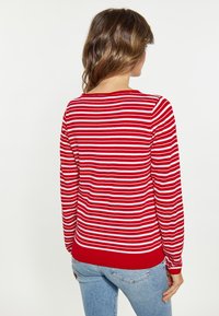 Pulover cu mânecă lungă, rayat roșu și alb, cu tiv și manșete ribbate, având un guler rotund și o textură netedă de tricot.
