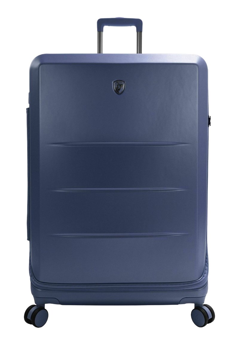 Blauer Hartschalenkoffer mit glänzender Oberfläche, vertikalen Rillen, ausziehbarem Griff und vier schwarzen Rädern für Mobilität.