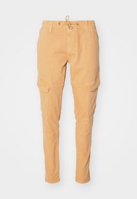 Beiga cargobyxor med dragsko i midjan, smalnande ben och två sidofickor på varje ben, tillverkade av mjuk bomull.