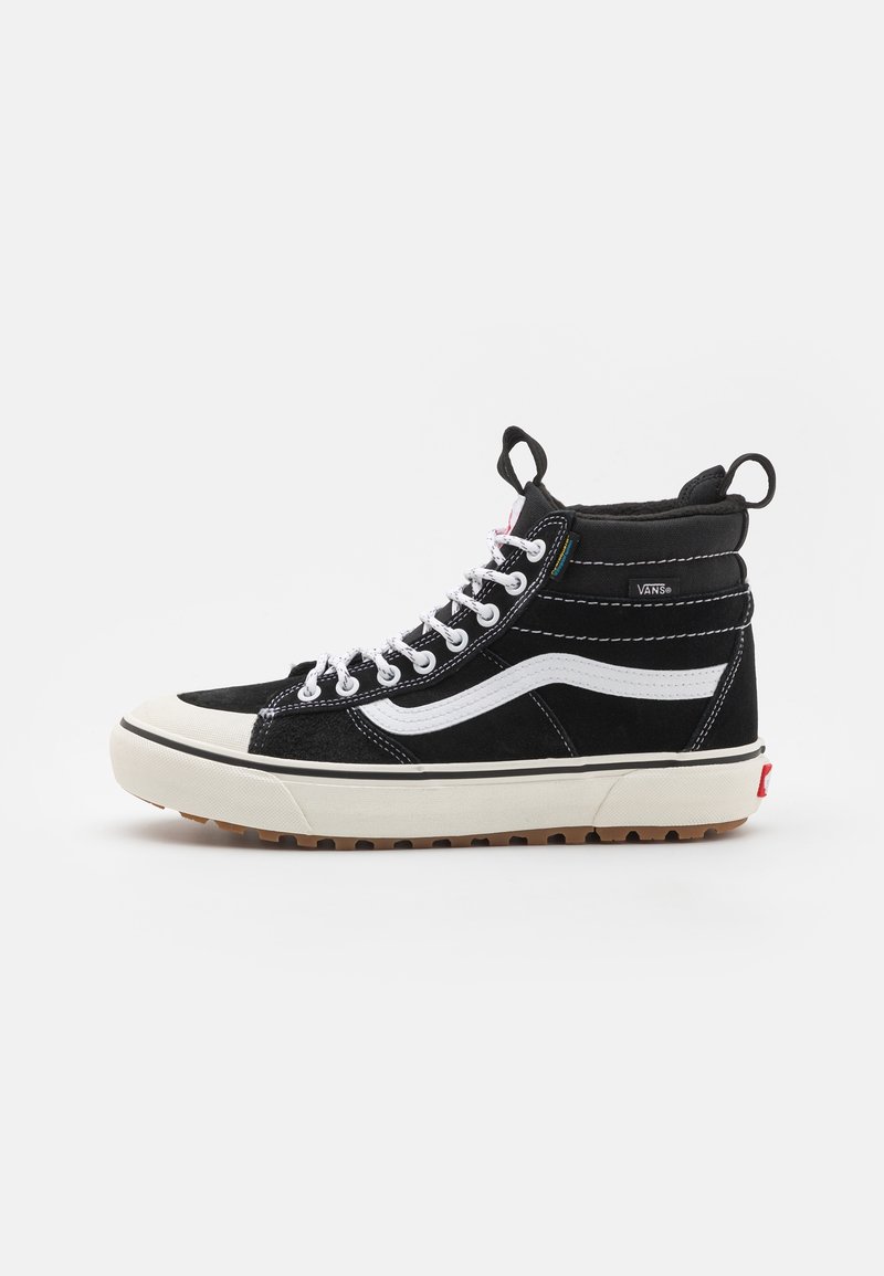 Baskets montantes Vans noir et blanc avec lacets blancs, bande latérale blanche, languettes de traction et semelle épaisse en caoutchouc avec motif texturé.