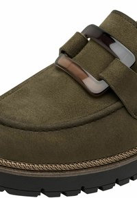 Chaussure en daim vert olive avec une grande boucle en écaille sombre, semelle épaisse et couture détaillée le long du bord.