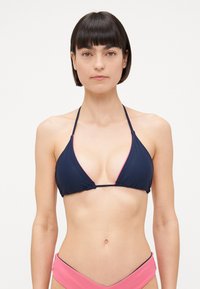 Trokutasti bikini top u tamnoplavoj boji s ružičastim akcentima, s tankim trakama i minimalističkim dizajnom. Glatka tkanina s mekanom teksturom.