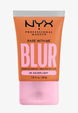 Tube de fond de teint avec un corps pêche-orange, un capuchon rose et un texte noir. L'étiquette indique "BLUR" et "08 : Lumière dorée", avec une texture lisse.