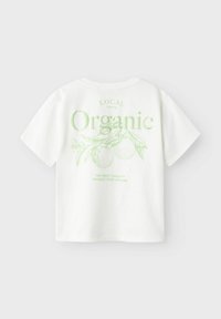 Witte katoenen t-shirt met korte mouwen, voorzien van een groen grafisch ontwerp over biologische landbouw, inclusief bladeren en twee cirkelvormige ontwerpen.