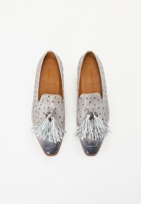 Mocassins en cuir texturé gris avec quincaillerie en ton argenté, présentant un détail de à pampilles proéminent et un embout brillant contrastant.