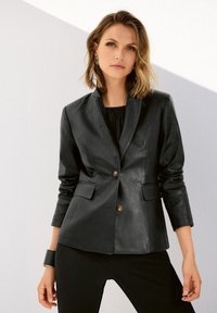 Zwart leren blazer met een getailleerd ontwerp, voorzien van twee voorzakken en een enkele knoopsluiting. Gladde textuur met een op maat gemaakte silhouet.