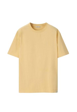 Effen gele katoenen T-shirt met korte mouwen, ronde hals en een klein labeltje bij de zoom, op een witte achtergrond.