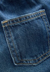 Denim tkanina z majhno, šivano zadnjo žep.