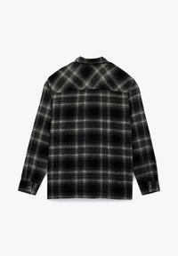 Musta ja harmaa ruudullinen paita pitkillä hihoilla, napitetuilla hihansuilla ja kauluksella. Ominaisuudet ovat teksturoitu kangas, jossa on vaihteleva neliökuvio.