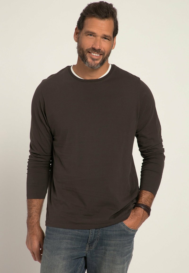 Dunkelbraun longsleeve Hemd mit einem weißen Rundhalsausschnitt, kombiniert mit hellblauen Jeans; glatte Stofftextur und entspannte Passform.