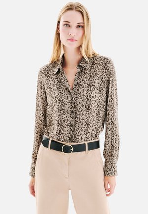 Chemise à manches longues en tissu marron et beige avec un motif détaillé, dotée d'un col et d'une fermeture à boutons, assortie à une ceinture noire.