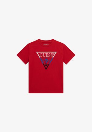 Crvena pamučna majica kratkih rukava s trokutastim logotipom u plavoj i srebrnoj boji, s natpisom "GUESS" i upitnikom.