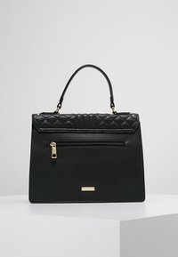 Svart handväska med en strukturerad design, som har en kviltad ovandel, framficka med dragkedja, detaljer i guld, och ett enkelt handtag.