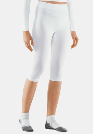 Witte capri leggings met een geribbelde structuur, hoge tailleband en lengte tot midden de kuit. Gecombineerd met grijze en witte enkelsokken.