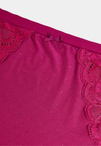 Fuchsia stof met een getextureerd stippenpatroon, met kantafwerking aan één kant en een klein strikdetail aan de bovenrand.