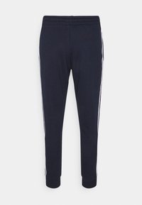 Marina idrottsbyxor med avslappnad passform, som har vita sidostråck, elastisk midja och ribbade muddar vid anklarna. Mjuk tygstruktur.