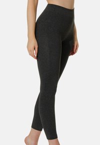 Leggings a vita alta, aderenti, in un tessuto grigio scuro con una superficie liscia e senza motivi o dettagli visibili, che si stringono alla caviglia.