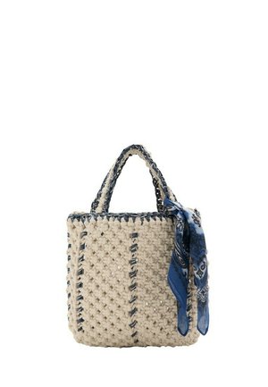 Sac à main carré en crochet crème avec bordures et poignées bleu foncé, décoré d'un foulard noué à motif cachemire bleu sur la poignée.