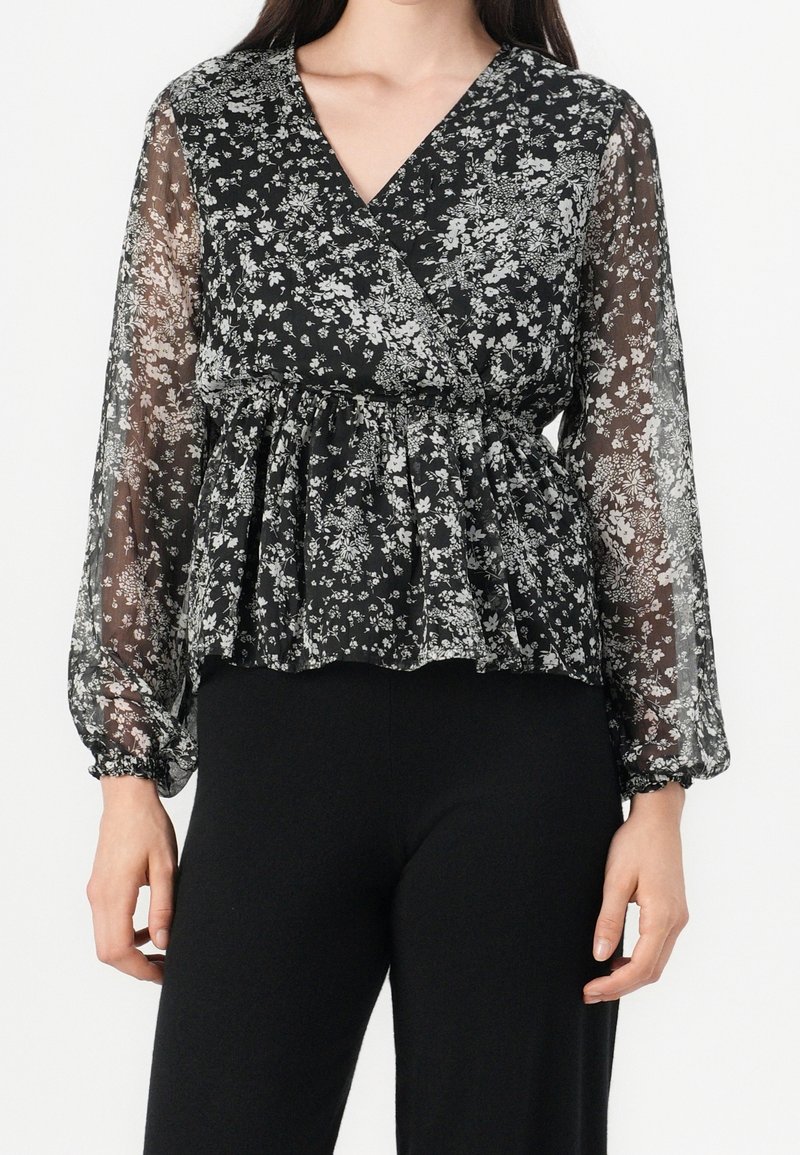 Schwarze Bluse mit floralem Muster, langen durchsichtigen Ärmeln, V-Ausschnitt und geraffter Taille. Mit weißen Blumenmustern und einer leichten, fließenden Textur.
