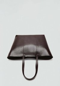 Bruine leren tote bag met vlak ontwerp, twee handvaten en zichtbare stiksels. Dikke textuur en minimalistische vorm. Geen hardware of accenten.