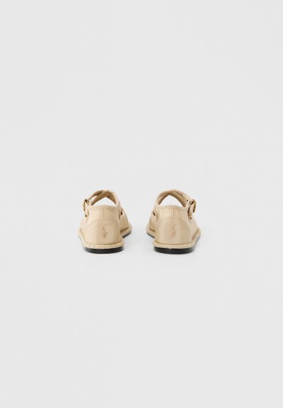 Μπεζ παπούτσια τύπου slip-on με υφασμάτινο επάνω μέρος με υφή, πίσω λουράκι και κεντημένο λογότυπο στη φτέρνα. Λαστιχένια σόλα και λεπτομέρειες ραφής.