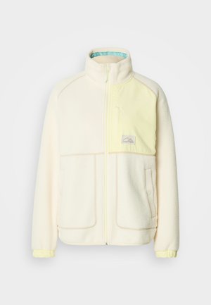 Veste polaire crème avec une poche poitrine jaune, fermeture éclair, col et poignets élastiques. Présente un logo de montagne sur la poche poitrine.