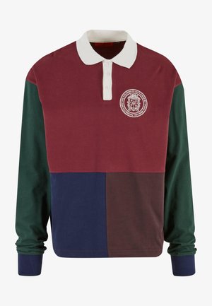 Polo a maniche lunghe con un design a blocchi di colore marrone e verde, colletto bianco, patta con tre bottoni e un emblema sul petto.