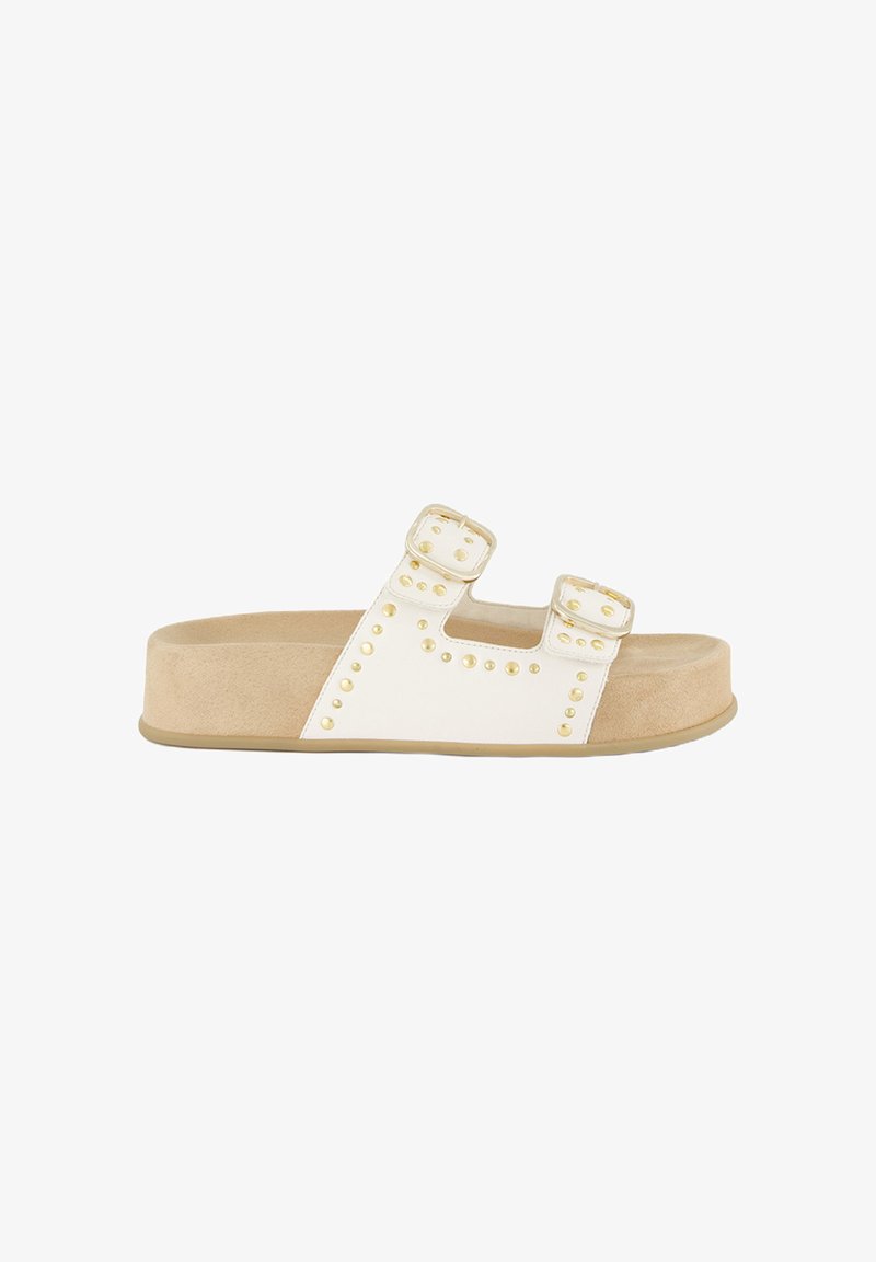 Weiße Riemchensandalen mit zwei verstellbaren Riemen und goldenen Nieten, einem gepolsterten beigen Fußbett und einer robusten tanfarbenen Außensohle.