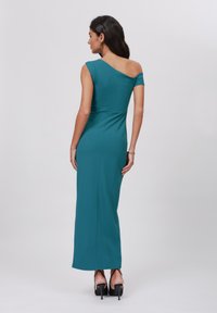 Teal off-shoulder maxi dress in stretchy fabric with a fitted silhouette and a side slit. Features a smooth texture and sleek, minimal design.