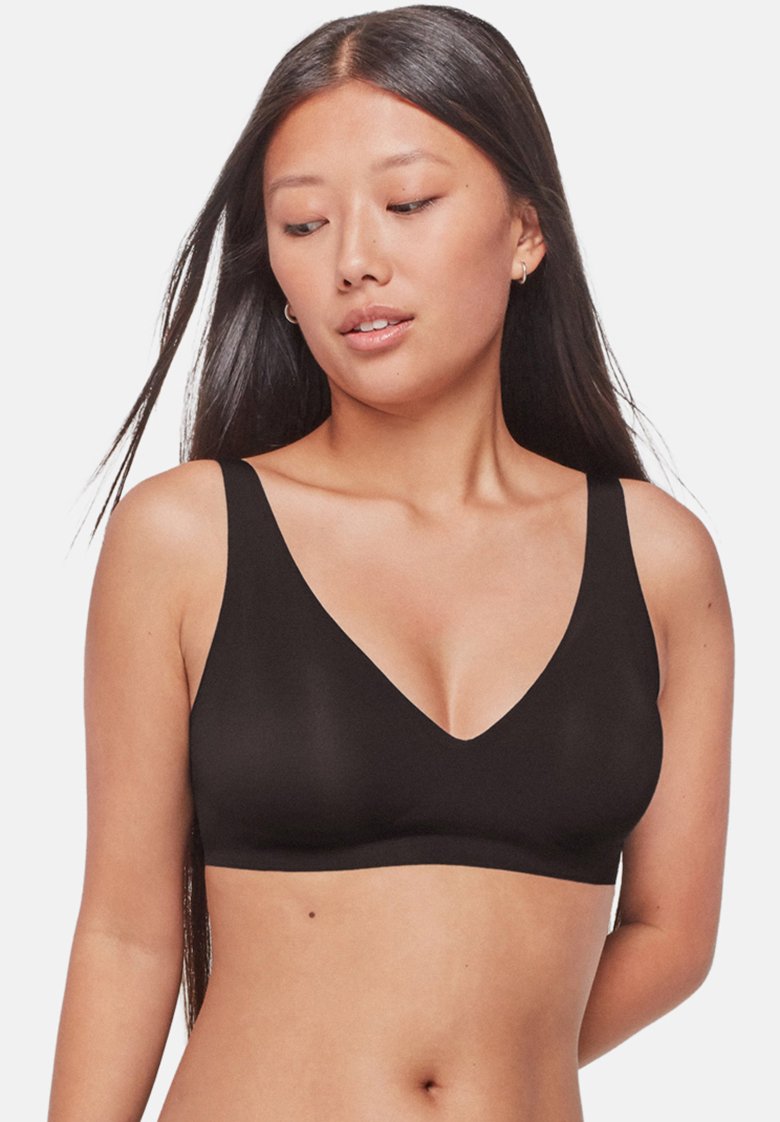 Bralette negra sin aros con un profundo escote en V y tirantes anchos, que presenta una tela suave y elástica, así como un diseño minimalista.
