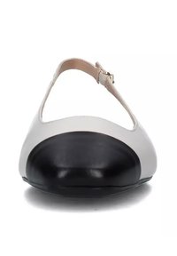 Scarpa bicolore bianca e nera con punta tonda, cinturino alla caviglia regolabile e una texture liscia e opaca. Presenta un tacco basso e curvato.